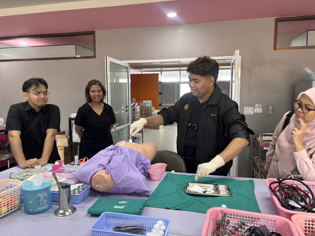 IIUM nursing student demonstrating wound dressing techniques in the clinical simulation lab at Walailak University School of Nursing.